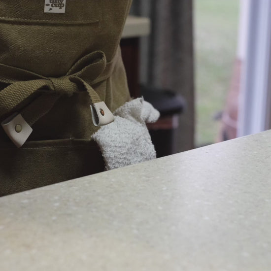 video of barista pouring maple syrup into the bottom of a circle-shaped glass cup.
