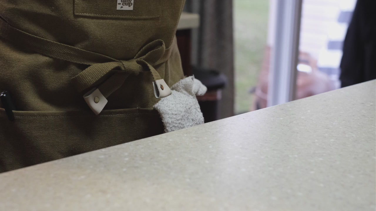 video of barista pouring maple syrup into the bottom of a circle-shaped glass cup.